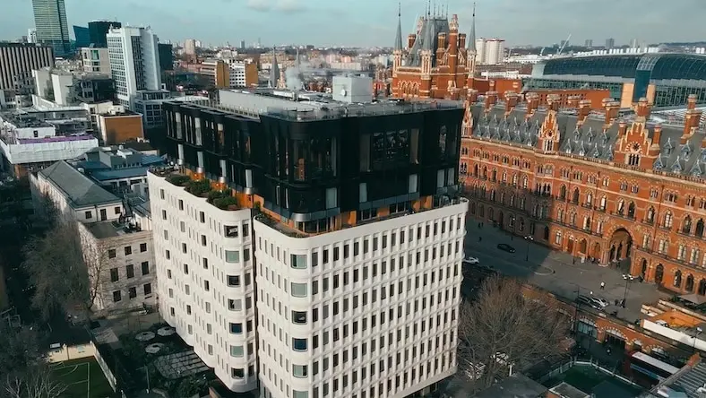 Aerial view of The Standard London, a repurposed 1970s building situated next to the Victorian Gothic St. Pancras railway station.