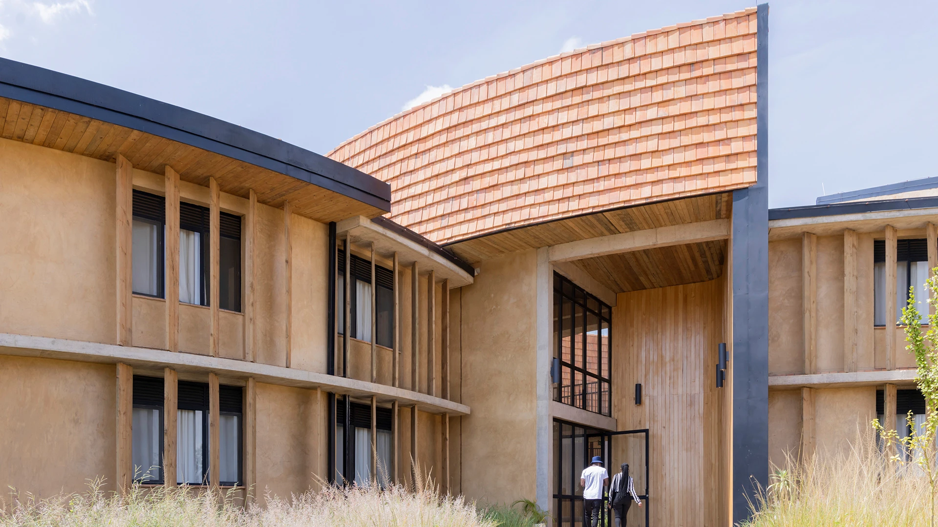 A detail of RICA’s exterior, featuring terracotta roof tiles and rammed-earth blocks.