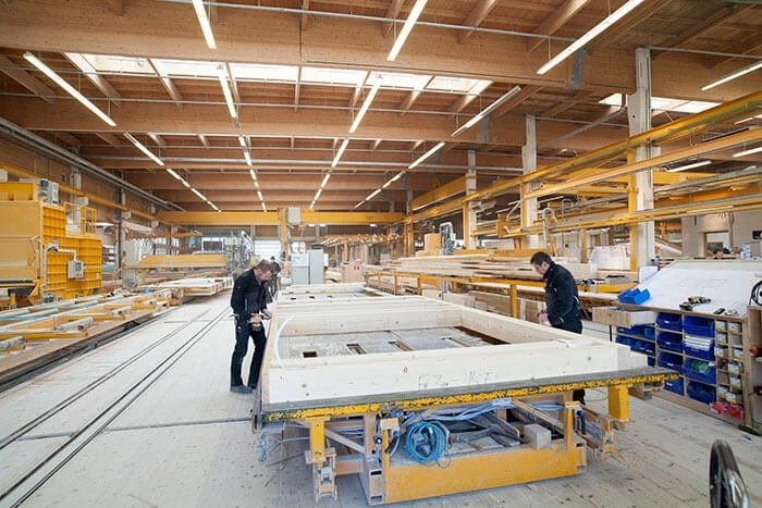 Baufritz employees work on prefab housing components.