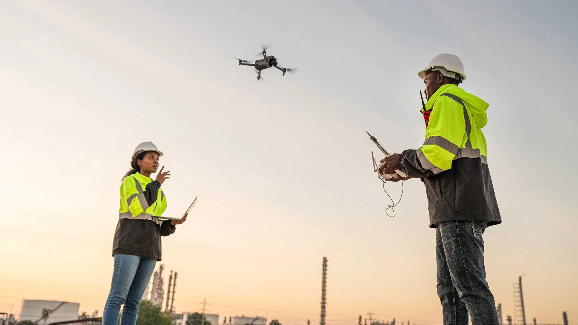 Über zwei Mitgliedern eines Bauteams schwebt eine Drohne.