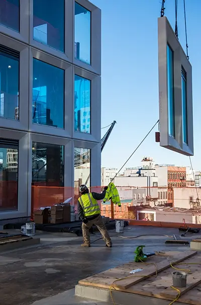 a prefabricated window is lowered into place in a building facade.