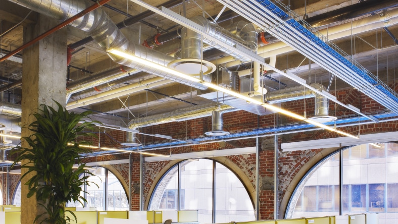 A ceiling view of a building interior with a view of the duct system