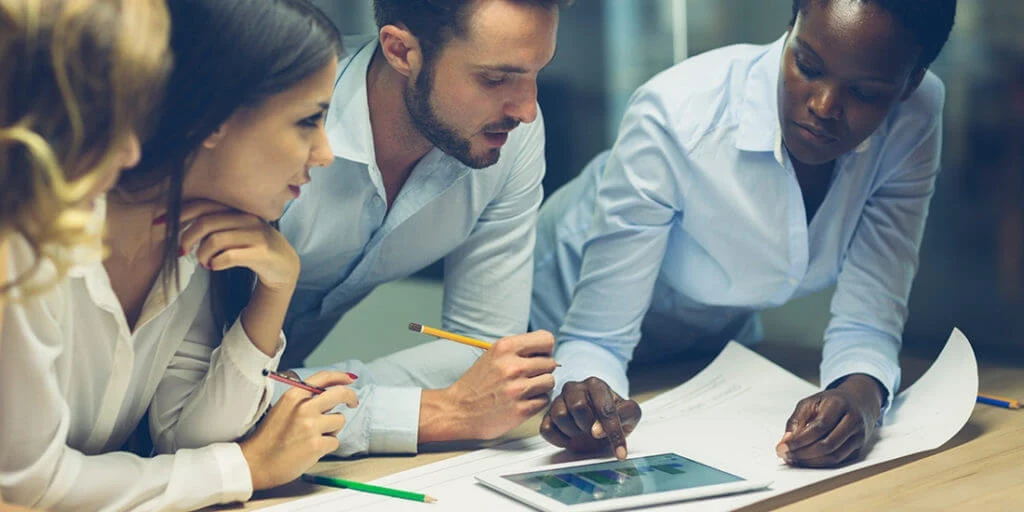 Four architects collaborating on a tablet