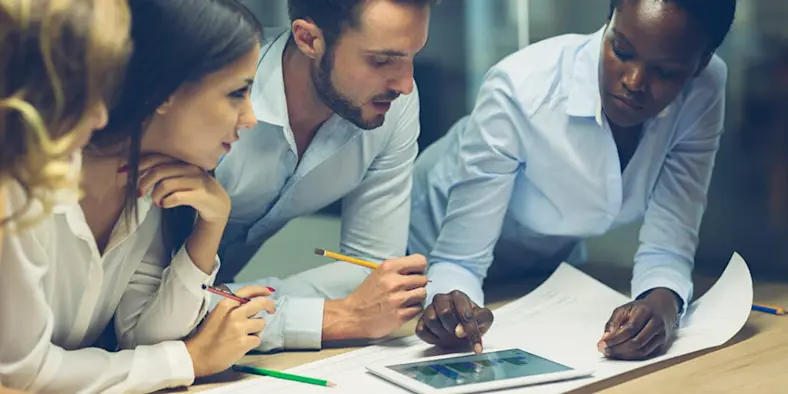 four architects collaborating on a tablet
