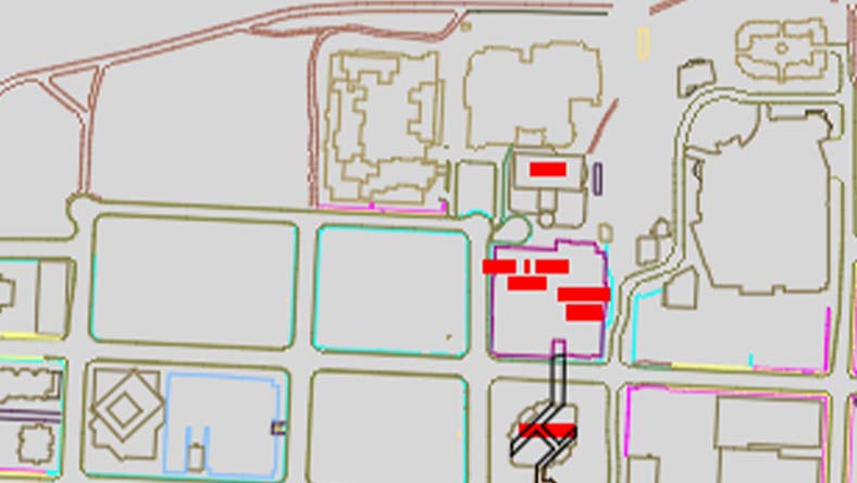 Map with outlined buildings, roads, and red rectangles marking specific locations in a central area.