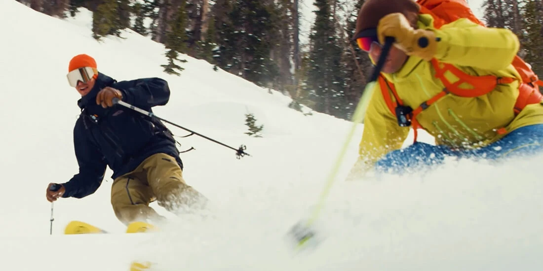 Two people skiing down a hill.