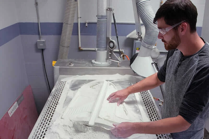 A worker prepares a 3D-printed seat-frame mold at Aristo Cast.