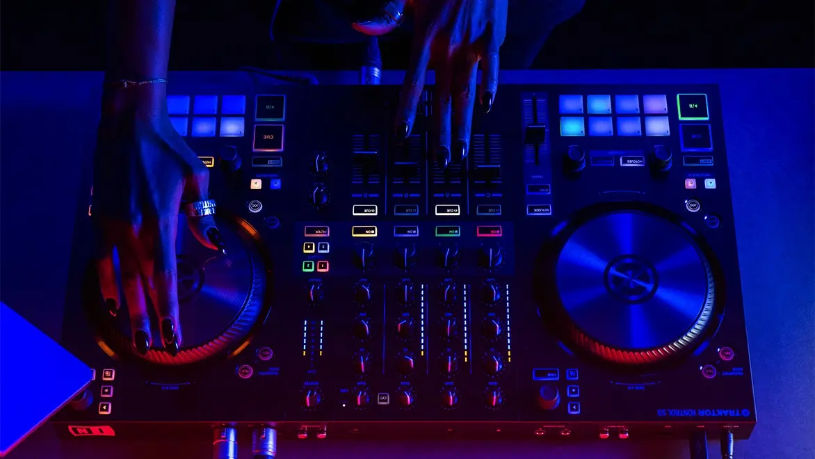 Hands manipulate the spin wheel of a DJ mixing board