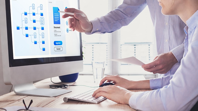 An office worker manages documents on a computer.