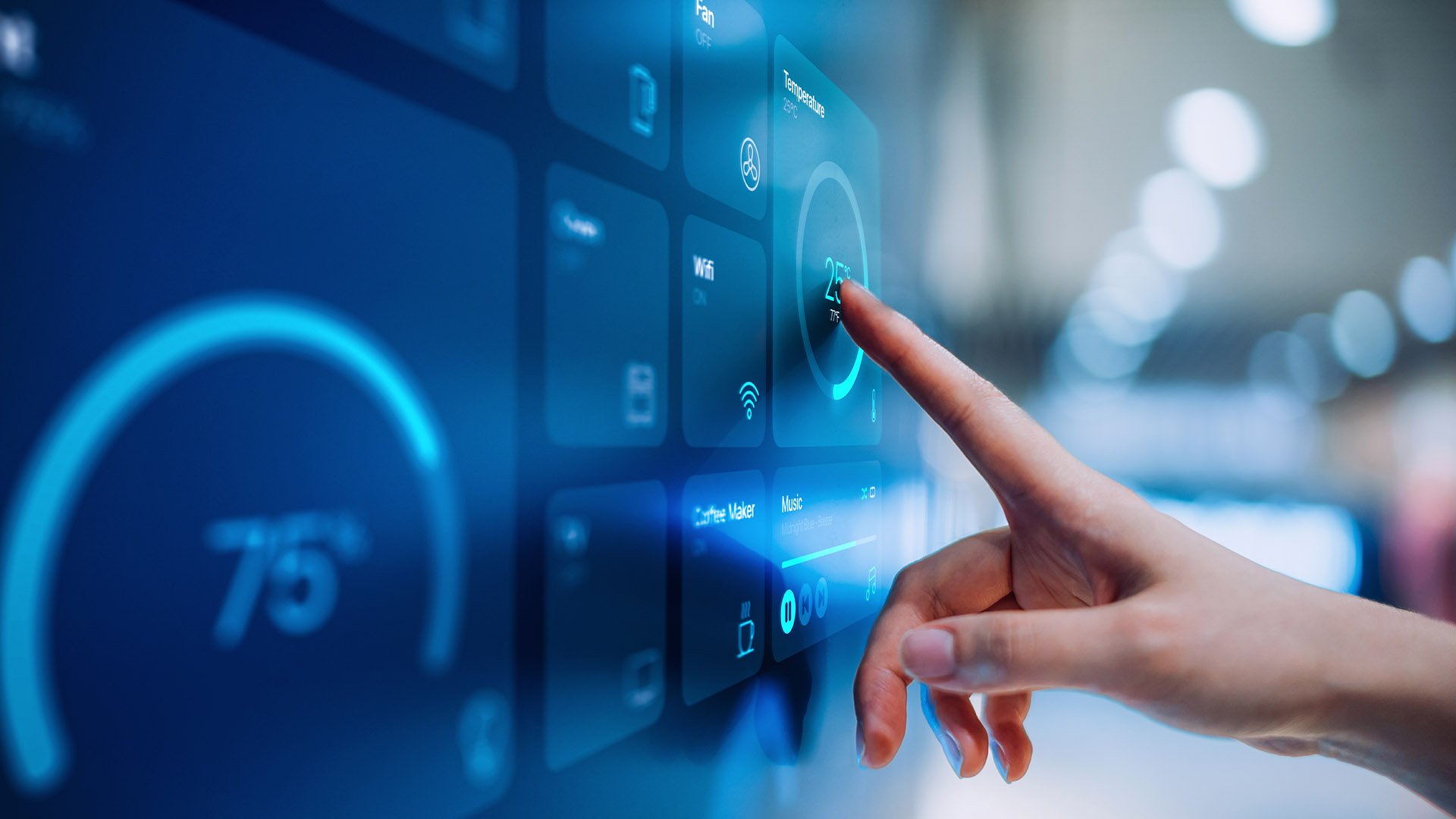 A woman's hand is touching a wall panel that controls building climate.