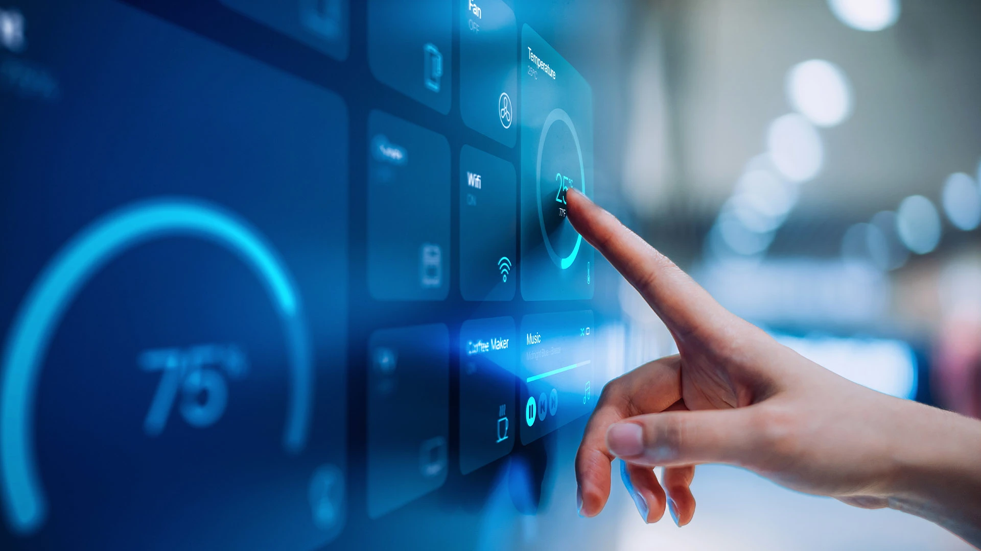 A woman's hand is touching a wall panel that controls building climate.