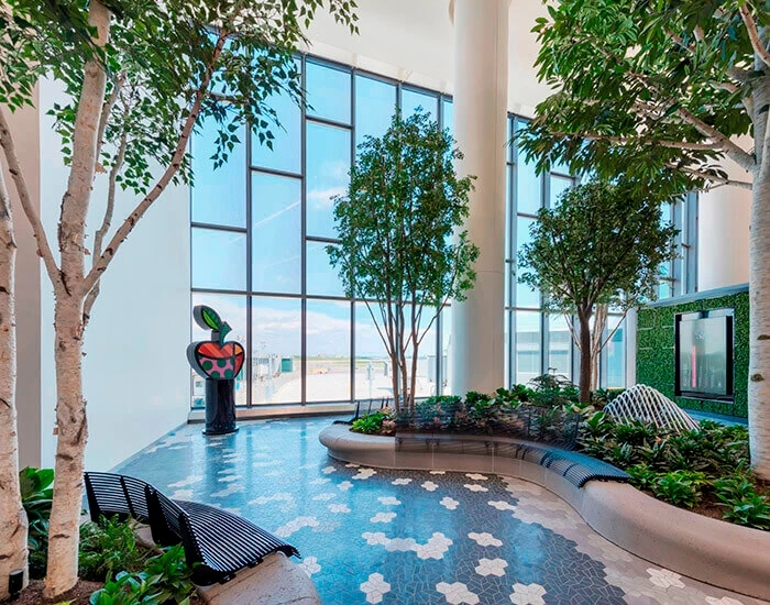 Interior view of an airport with greenery and trees inside