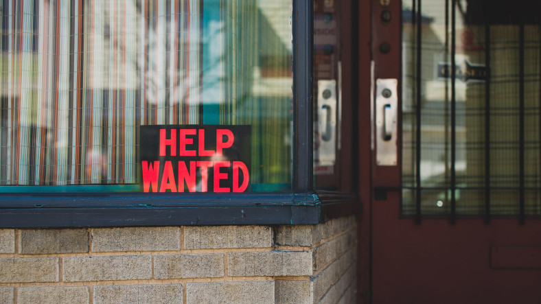 “Help Wanted” sign in a storefront window