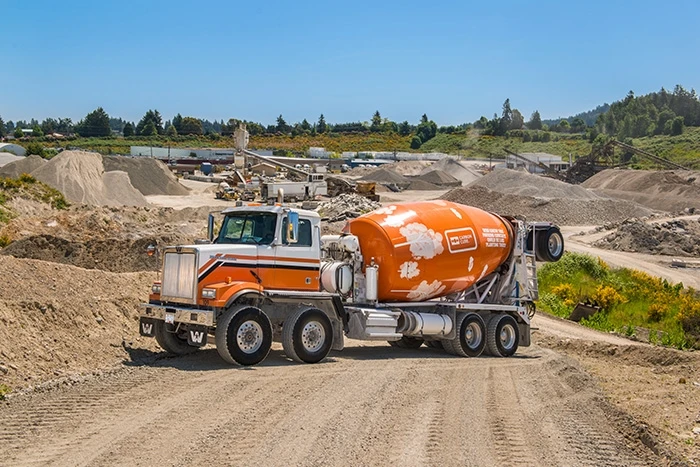 Orange cement truck at a concrete plant