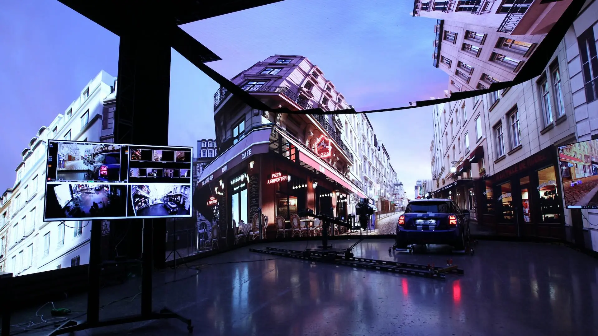 Ein Filmstudio bei Dexter Studios zeigt Straßenansichten auf LCD-Surround-Bildschirmen.