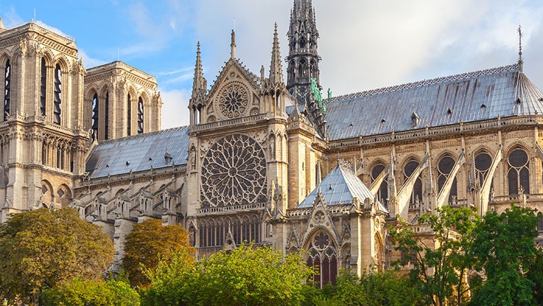 An exterior view of Notre Dame Cathedral shows detailed stone architecture.
