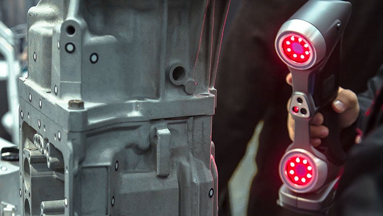 An engineer scans a part with a 3D scanner.