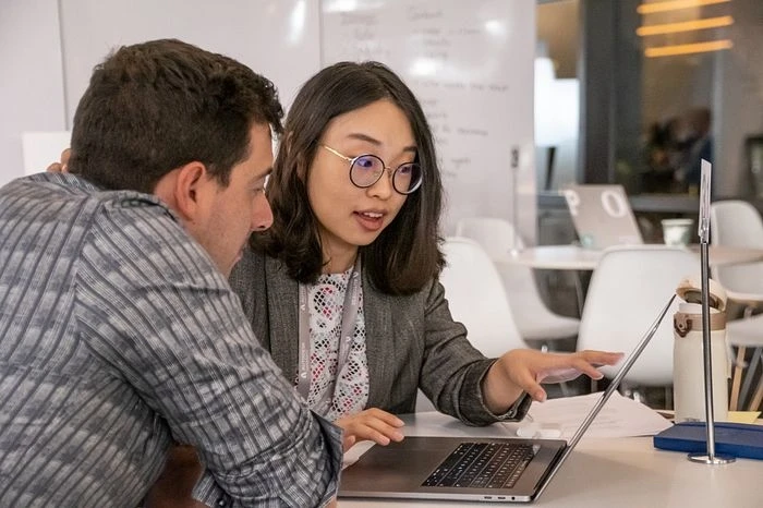 Two people look at laptop