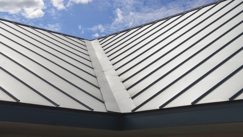 Seam of a metal roof with blue sky in the background.