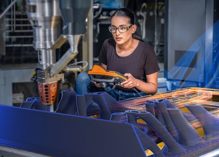 woman working with additive manufacturing robot