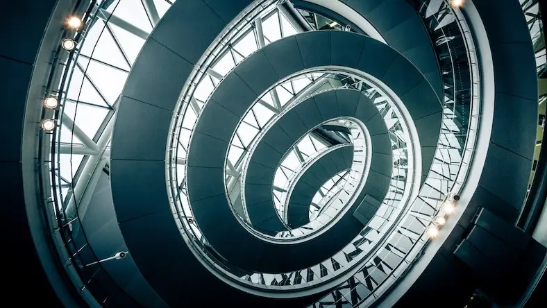 An interior photograph of London’s City Hall illustrates circular steel architectural elements.