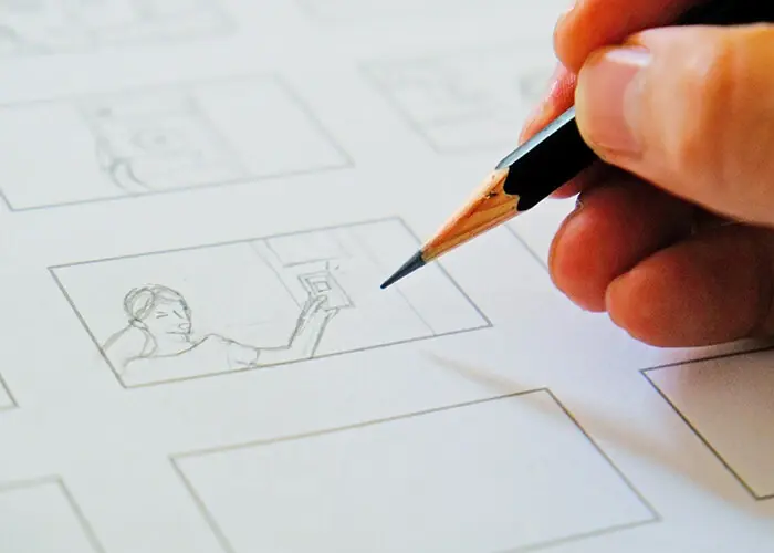 a picture of a hand holding a pencil drawing on a storyboard