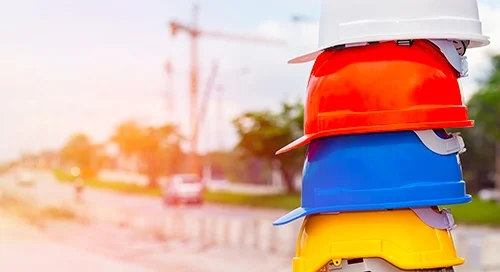 Construction helmets are stacked in a pile.