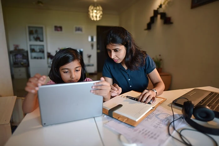 Mother and daughter on laptop working on homework