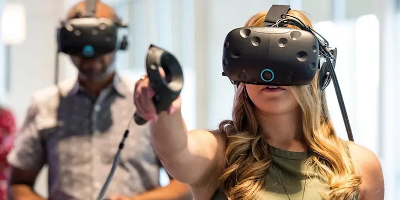 Woman wearing a VR or AR headset and gesturing with handheld controller