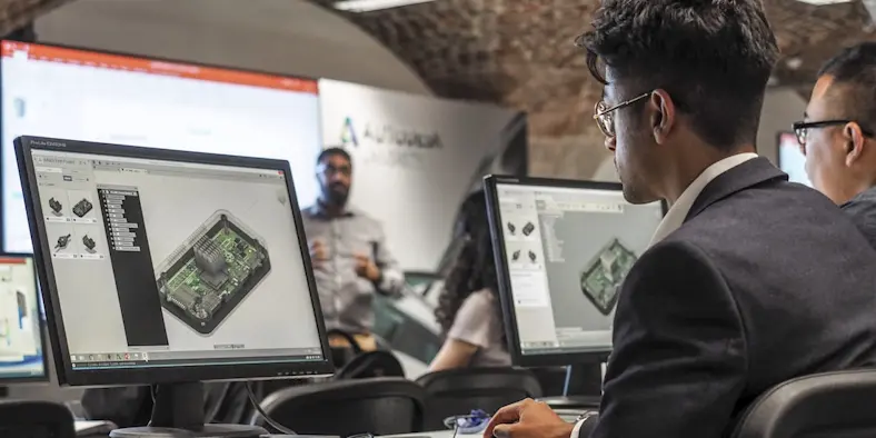 Office workers sit in front of monitors