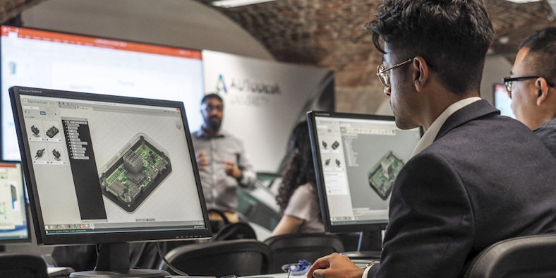 Office workers sit in front of monitors