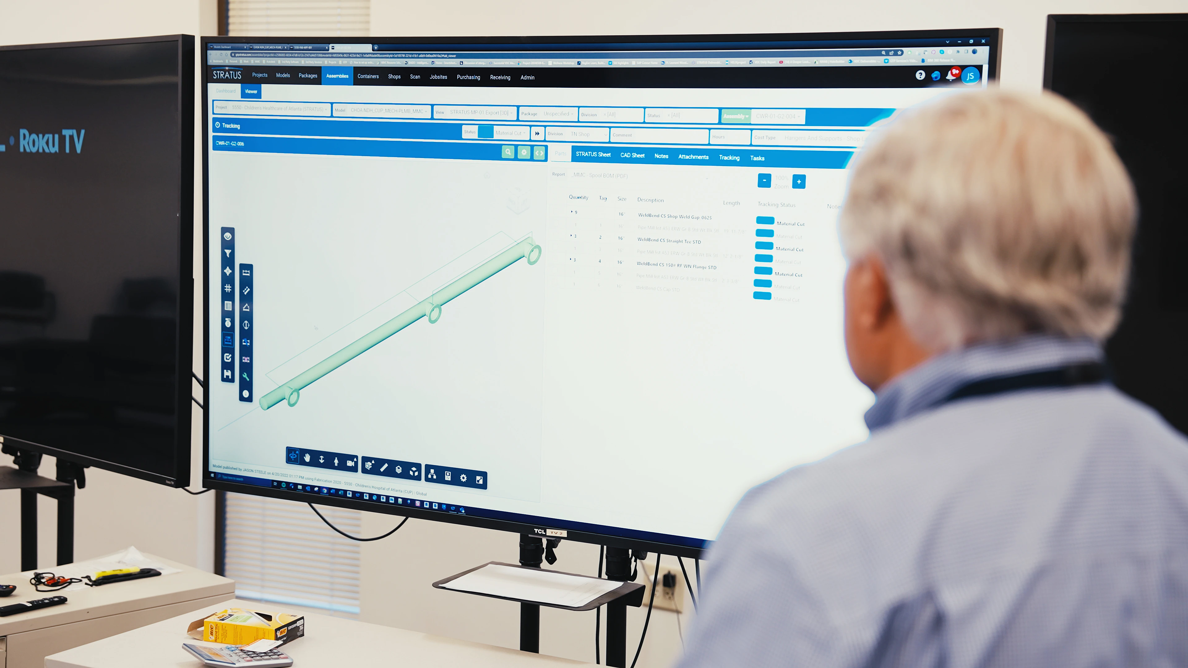 Man standing in front of large flat-screen monitor viewing BIM model