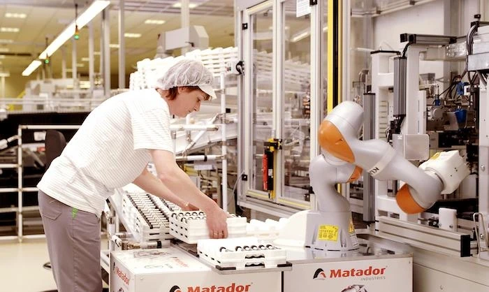 Woman working with the Kuka LBR iiwa robot at Skoda Auto 