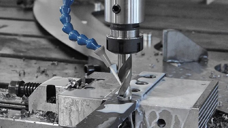 A robotic drill cuts holes in a steel sheet.