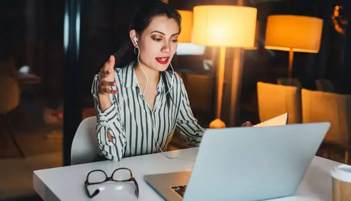 A woman takes a video call from her home office