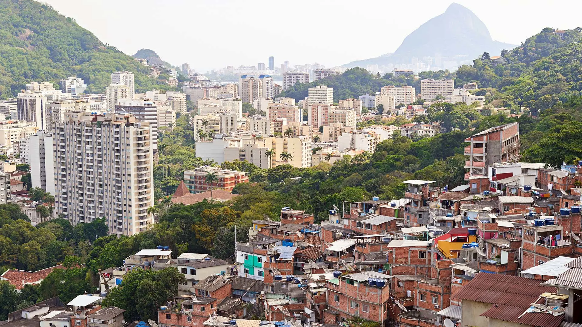 Une image de Rio de Janeiro montre des gratte-ciel d’un côté et des quartiers défavorisés de l’autre.