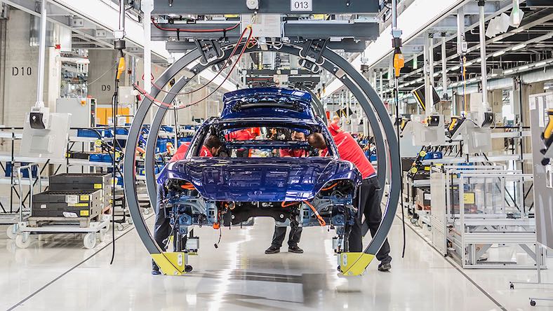 industrial engineering porsche car on factory assembly line