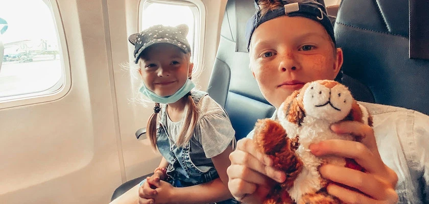 Two kids sitting in airplane seats