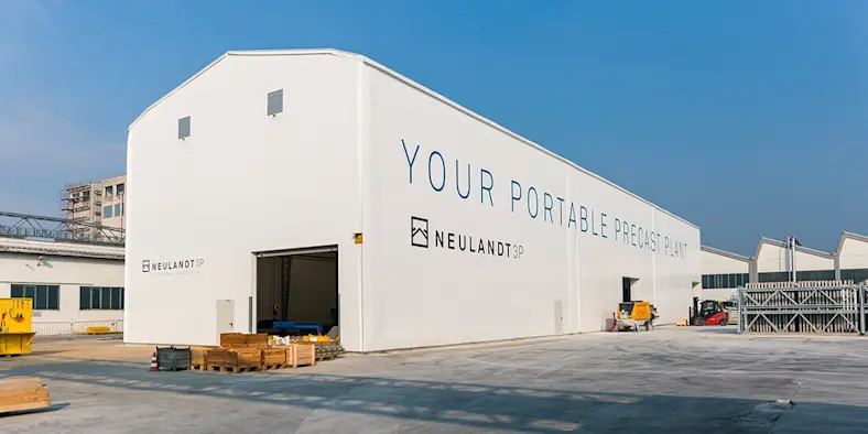 Building affordable housing: Today, Austria; tomorrow, Africa: NEULANDT’s 3P portable precast plant is 230 feet (70 meters) long and 49 feet (15 meters) wide.