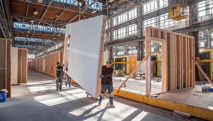 construction workers with prefabricated panels for buildings