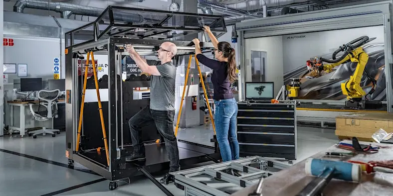 A man and a woman work on a project in a manufacturing setting