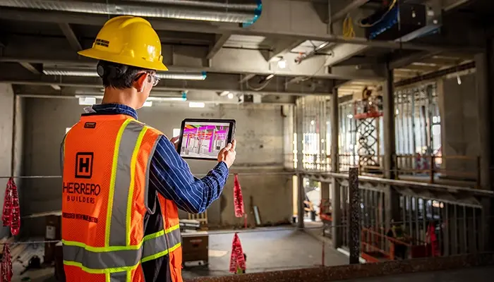 A man on a construction site visualizes work on a tablet
