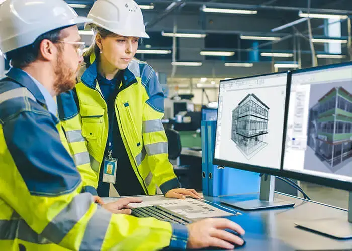 Spie batignolles construction workers review building plans on computer monitors.