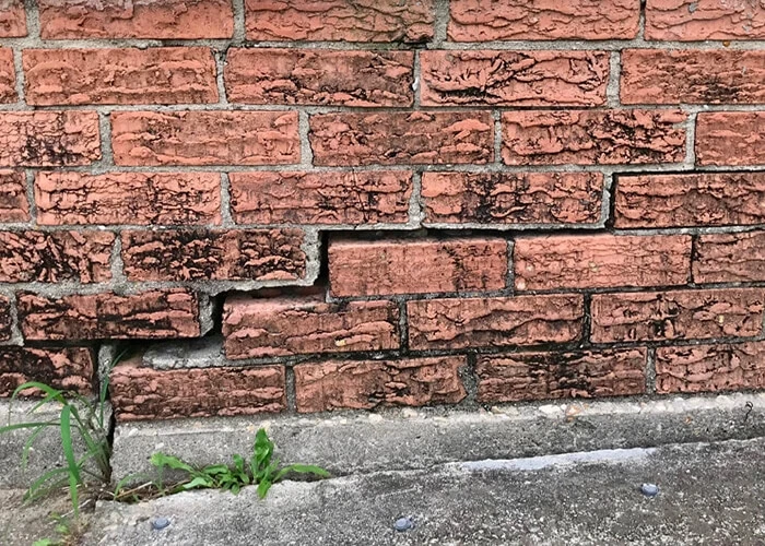a brick wall showing cracks in it