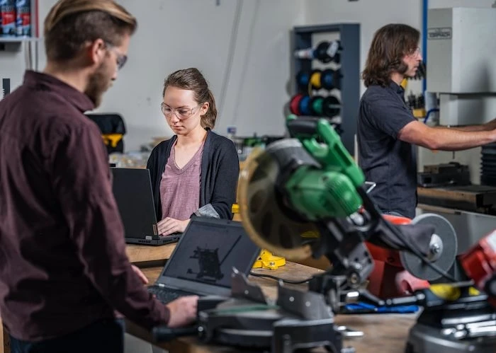 Three people working in a machine shop