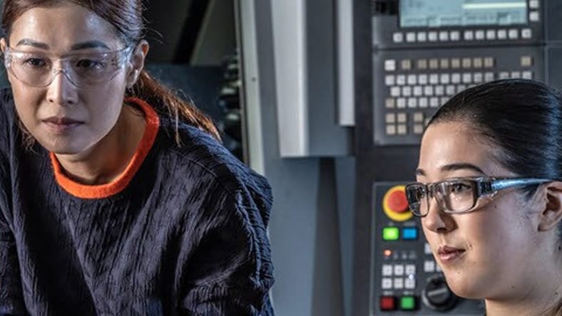 Two women working on computer.