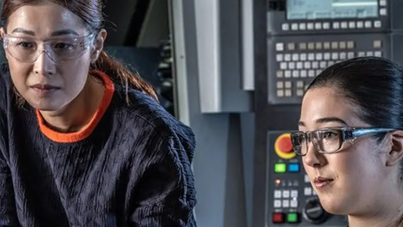 Two women working on computer.