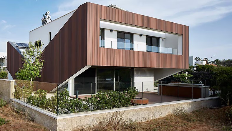 A sustainable, energy-positive home features wood cladding and solar panels.