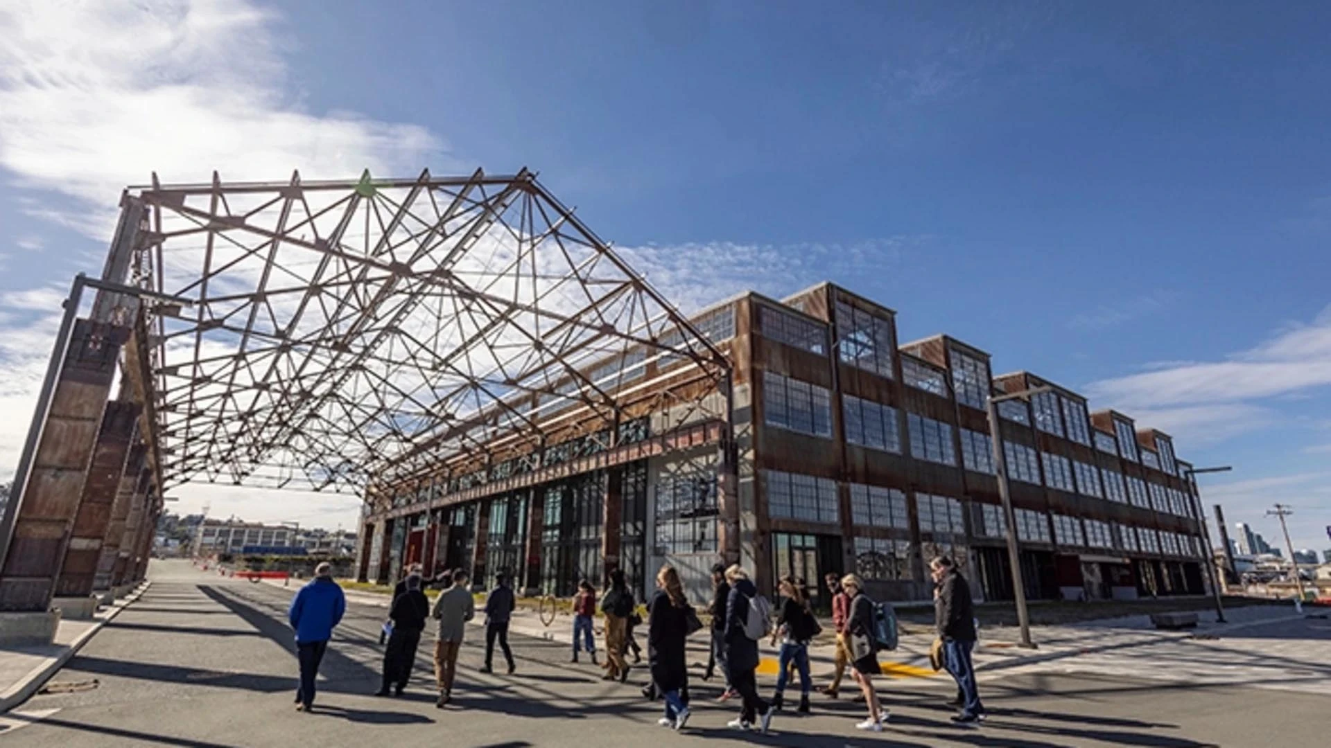 A group explores a repurposed warehouse under a steel canopy.