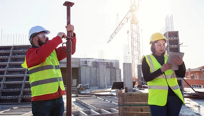 Construction workers access data using a tablet onsite, thanks to preconstruction